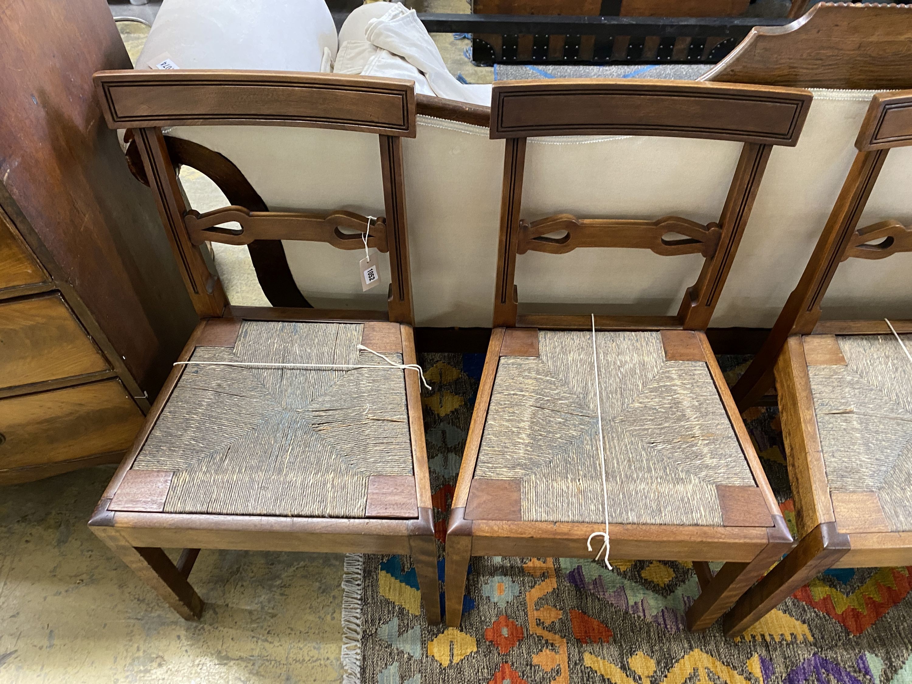 A set of six Regency provincial mahogany dining chairs with drop in rush seats